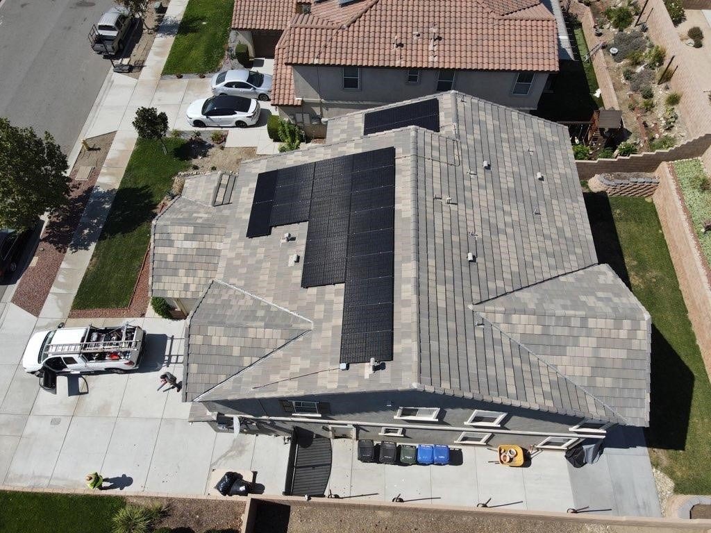 Aerial view of a residential array mid-installation, crew and truck on site